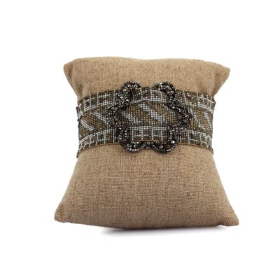 L'oreiller est en burlock et est orné d'une boucle décorative.