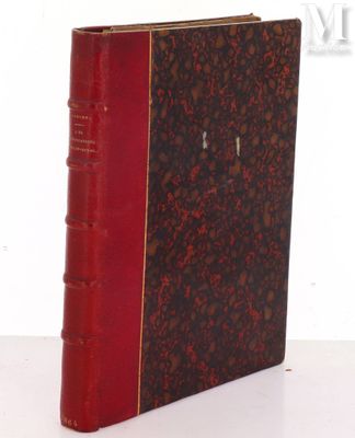 an old book sitting on top of a white table next to a white wall