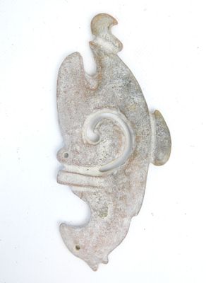 a stone sculpture of a fish on a white surface