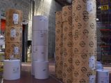many rolls of paper sitting on the floor in a warehouse