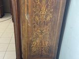 a wooden cabinet that has a gold design on it
