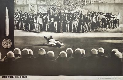 une photo en noir et blanc d'un homme allongé par terre devant une foule