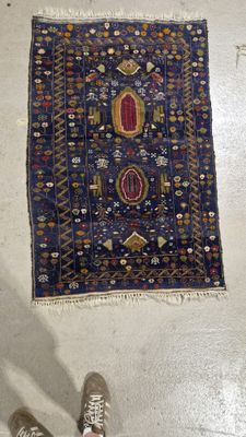 une personne debout à côté d'un tapis posé à même le sol