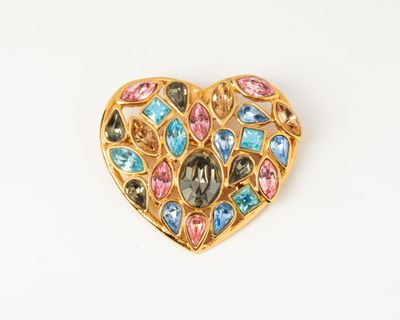 a close up of a heart shaped brooch with multi colored stones