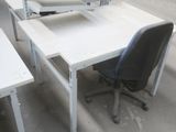 un bureau blanc sur lequel se trouve un ordinateur et une chaise noire