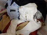 a pile of clothes in a suitcase on the floor