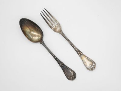 deux cuillères et une fourchette sur une surface blanche