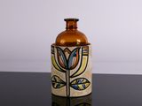 a vase with a flower on it sitting on a table