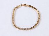 a close up of a gold bracelet on a white surface