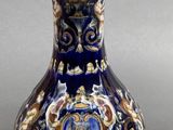 a blue and gold vase sitting on a gray surface