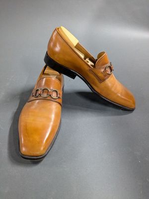 a close up of a pair of brown shoes on a gray surface