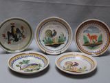 quatre assiettes à motifs différents posées sur une table
