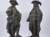three bronze statues of men with hats and tails standing next to each other