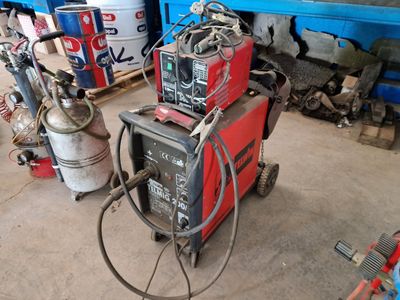 a welding machine in a garage with other equipment
