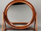 an image of a wooden mirror stand with a circular mirror on it