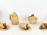 a group of wooden teapots and cups and saucers