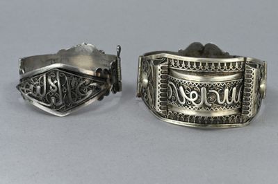 pair of silver cuff bracelets with the word never you engraved on them
