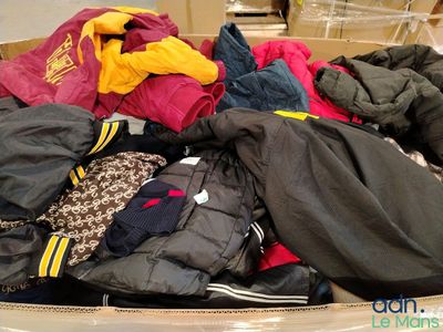 un gros tas de vêtements dans une boîte posée par terre
