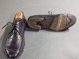 pair of purple leather shoes with laces on them on a gray surface