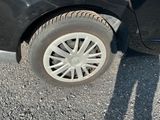 une voiture noire avec un pneu crevé sur une route en gravier