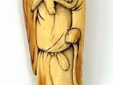 carved ivory figurine of a man carrying a bag