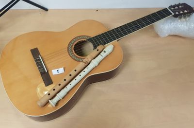 une guitare en bois et une flûte posées sur une table