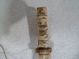 un petit couteau à manche en bois posé sur une surface blanche