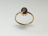 a close up of a gold ring with a garnetite stone
