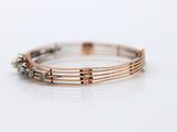 a close up of a bracelet on a table with a white background