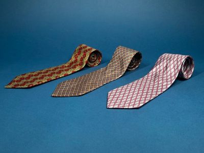 three different colored ties on a blue surface with a blue background