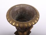 a bronze vase on a stand on a white background