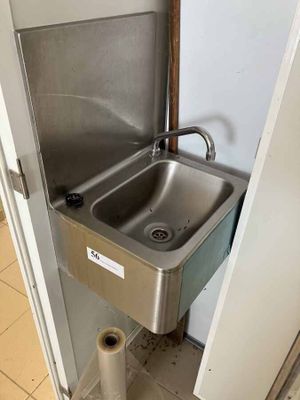 un évier en acier inoxydable dans le coin d'une salle de bains