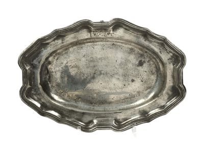 an antique silver plate with a scalloped edge on a white background