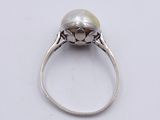 an image of a pearl and diamond ring on a white surface