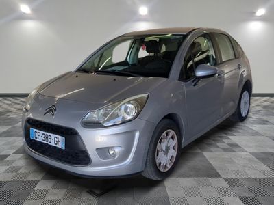 la petite voiture argentée est garée sur un carrelage à carreaux