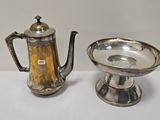 une théière en argent et une tasse en argent posées sur une table