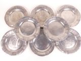several silver plates are arranged in a circle on a white surface