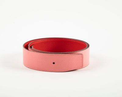 a pink leather belt with a metal buckle on a white background