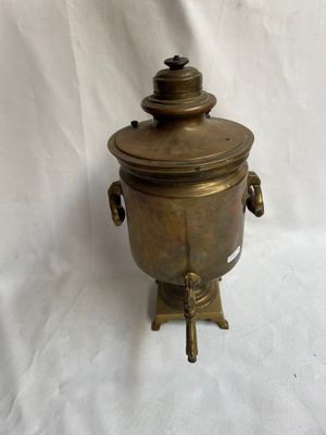 théière ancienne en laiton avec couvercle, posée sur un socle, sur fond blanc