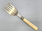 a fork with a wooden handle on a gray surface