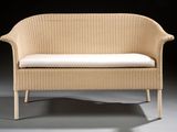an image of a wicker bench with a white cushion on it