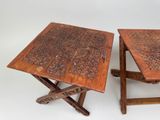 two wooden tables with carvings on them sitting on a white surface