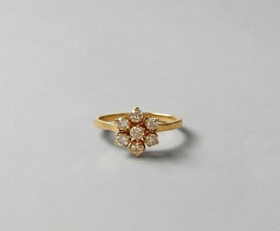 a close up of a yellow gold ring with a cluster of diamonds