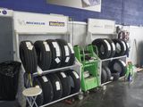 beaucoup de pneus empilés sur un support dans un garage