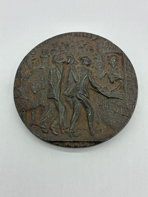 une vieille pièce de bronze sur laquelle figurent un homme et une femme