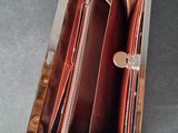 the inside of a wallet with a zipper open and a hand holding it