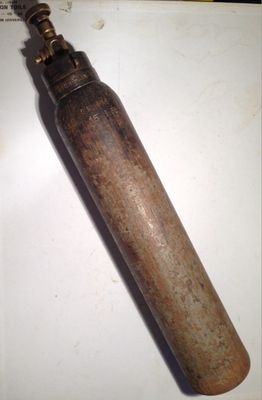 a small metal bottle with a wooden handle sitting on a table