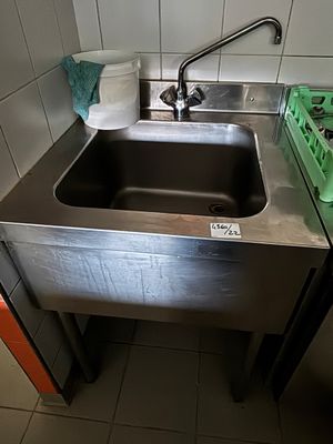 un évier de cuisine avec un panier vert à côté