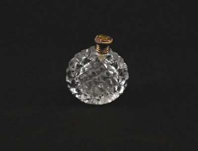 un flacon de parfum en verre transparent muni d'un bouchon doré