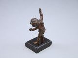 bronze figurine of a young boy holding a tennis racquet